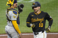 Pittsburgh Pirates' Bryan Reynolds (10) crosses home plate past Milwaukee Brewers catcher William Contreras after hitting a two-run home run off starting pitcher Bryse Wilson during the third inning of a baseball game in Pittsburgh, Wednesday, April 24, 2024. (AP Photo/Gene J. Puskar)