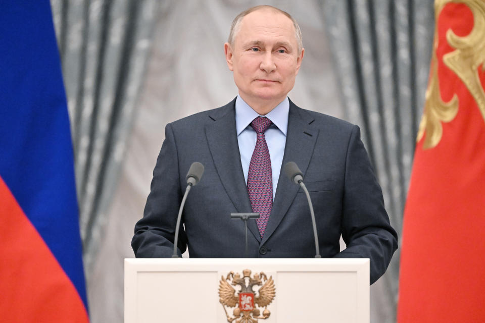 Russian President Vladimir Putin stands at a podium.