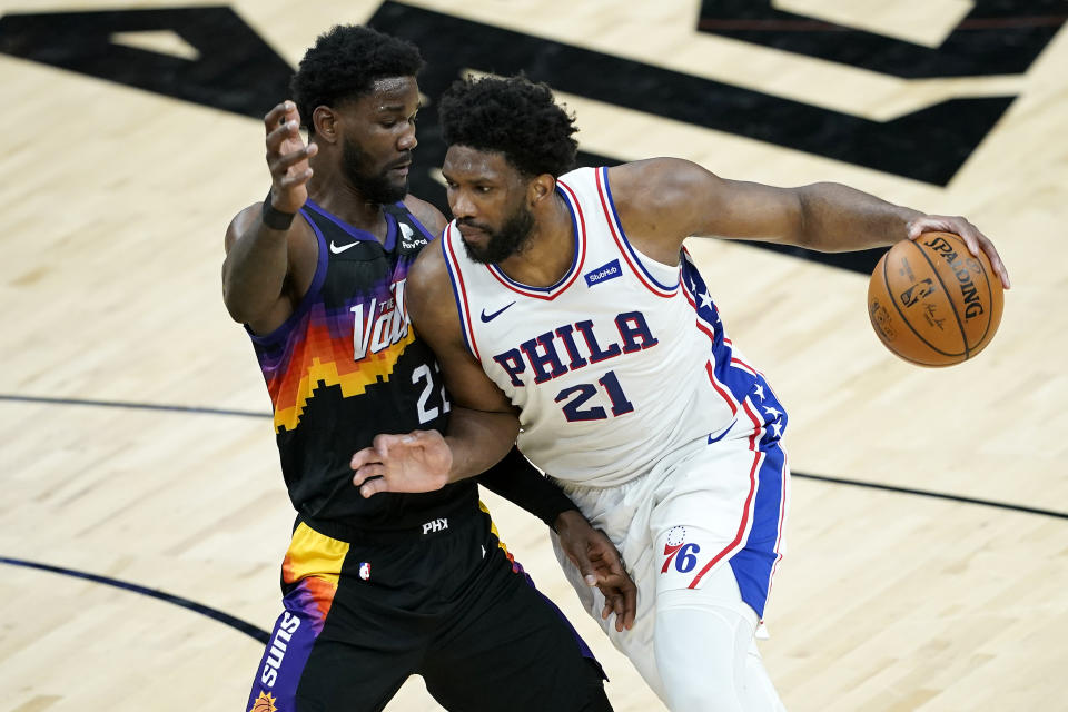 Philadelphia 76ers center Joel Embiid (21) drives on Phoenix Suns center Deandre Ayton during the first half of an NBA basketball game, Saturday, Feb. 13, 2021, in Phoenix.(AP Photo/Matt York)