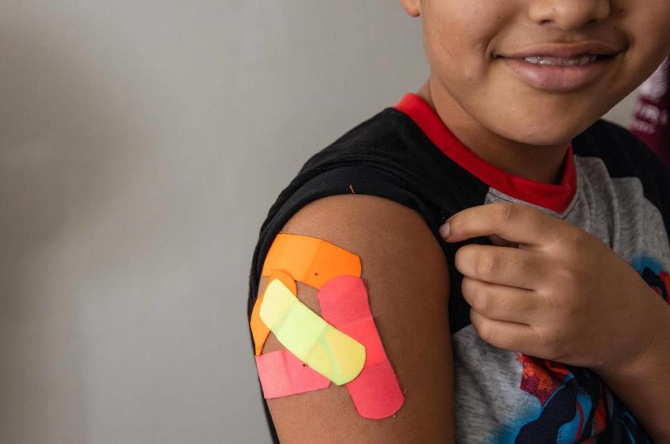 Omar Wahidi, 12, shows the bandaids from vaccines given to him in his right arm. Wahidi’s family fled from Afghanistan following the Taliban takeover. In order for him to attend school, he needed to receive all the required medical vaccinations.