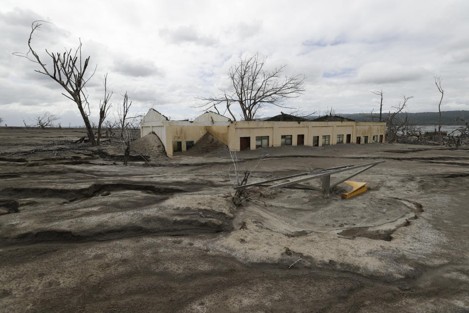 The remains of the Alas-as elementary school is seen buried in volcanic ash at Taal volcano almost a year after it erupted, on Sunday, Jan. 10, 2021 in Batangas province, Philippines. A popular tourist destination just south of Manila because of its picturesque setting in the middle of a lake, Taal erupted on Jan. 12, 2020. The eruption displaced thousands of villagers living near the area and delivered an early crisis this year for one of the world's most disaster-prone nations a couple of months before the COVID-19 pandemic broke in the country. (AP Photo/Aaron Favila)