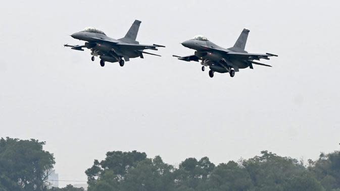 Dua pesawat tempur F-16V bersenjata terbang di atas pangkalan angkatan udara, Chiayi, Taiwan, 5 Januari 2022. Militer Taiwan menggelar latihan tempur darat, laut, dan udara di tengah ketegangan dengan China. (Sam Yeh/AFP)