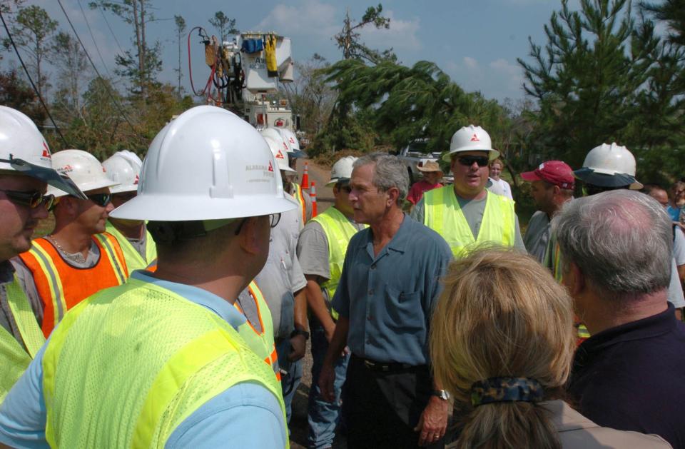 President Bush talks with a crew from Alabama Power Company during a tour to assess damage from Hurricane Katrina, Monday, Sept. 5, 2005, in Poplarville, Miss. The crew is in Mississippi to repair power lines. (AP Photo/The Hattiesburg American, George Clark)