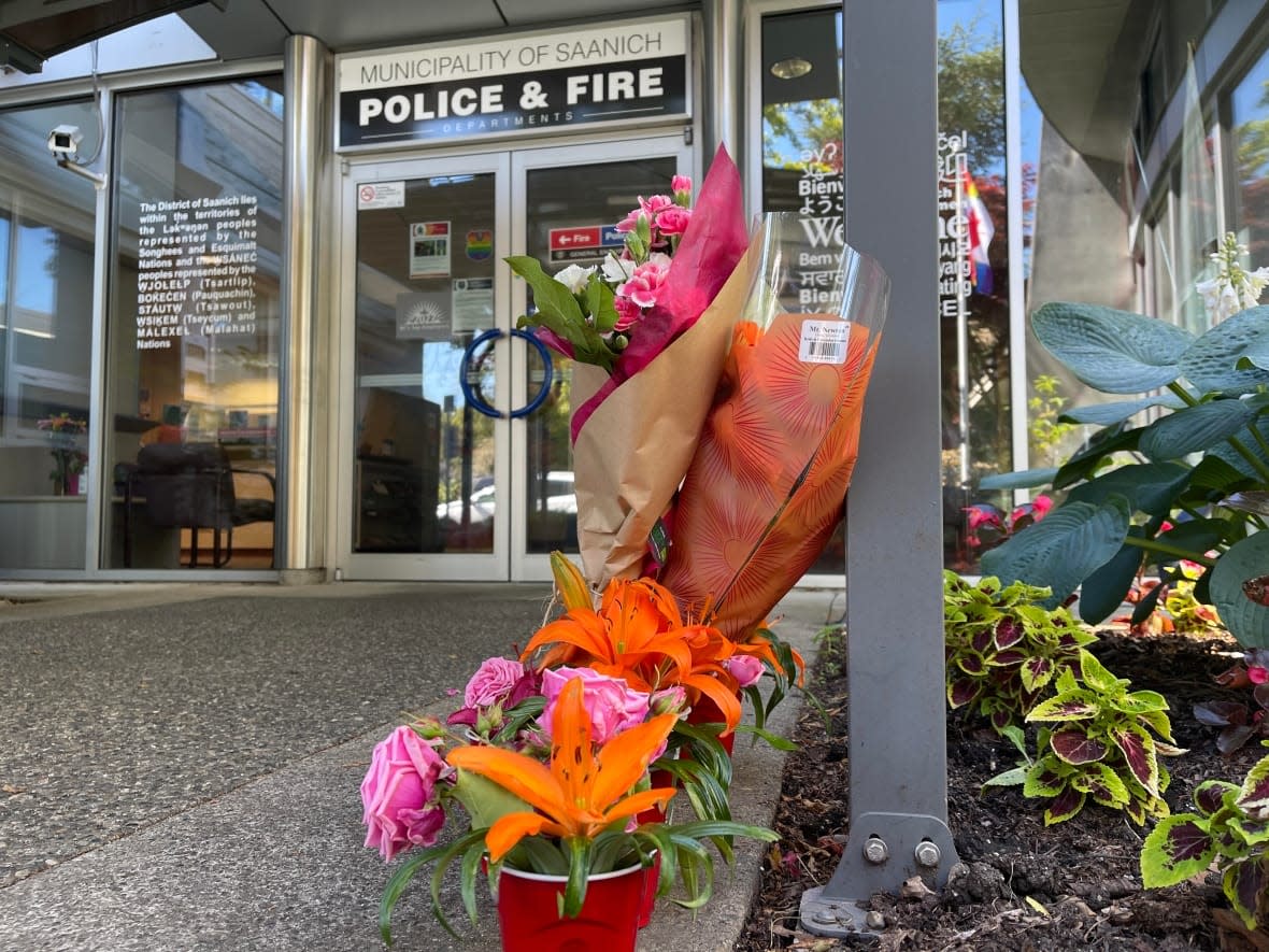 Flowers from members of the public are seen on Thursday, June 30, 2022 outside the entrance of Saanich Police Department, after six officers were wounded in a bank robbery two days earlier. (Susana da Silva/CBC - image credit)