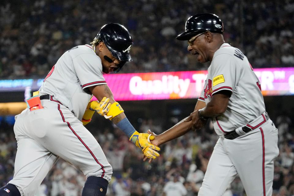 Atlanta Braves' Ronald Acuna Jr., left, is congratulated by third base coach Ron Washington after hitting a grand slam during the second inning of a baseball game against the Los Angeles Dodgers Thursday, Aug. 31, 2023, in Los Angeles. (AP Photo/Mark J. Terrill)