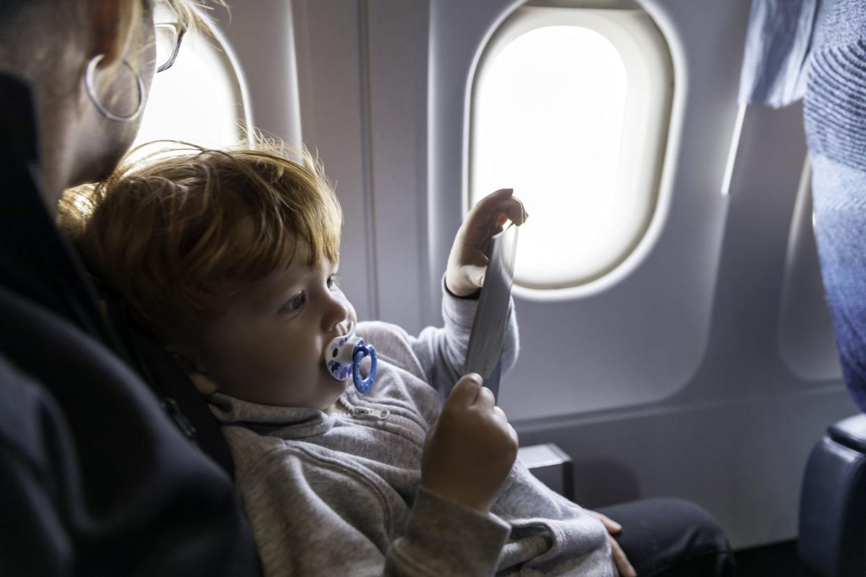 Young woman traveling with her little child by an airplane