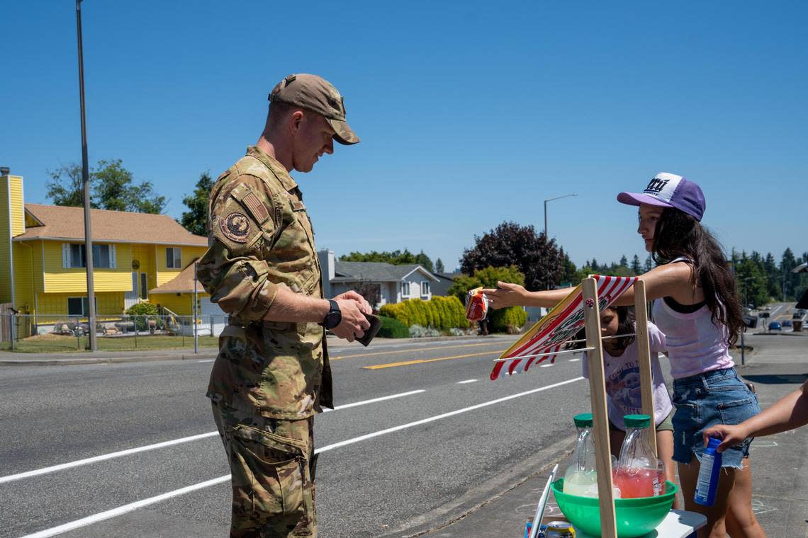 Nick Mackinnon purchasing a lemonade and some snacks from the local lemonade stand being ran by Layla DeWitt, 6, Zaylani Juarez, 10, Gabriela Sleeper, 6, and Leah Sleeper 13 on Monday June 27, 2022 in Norpoint Tacoma, Wash.