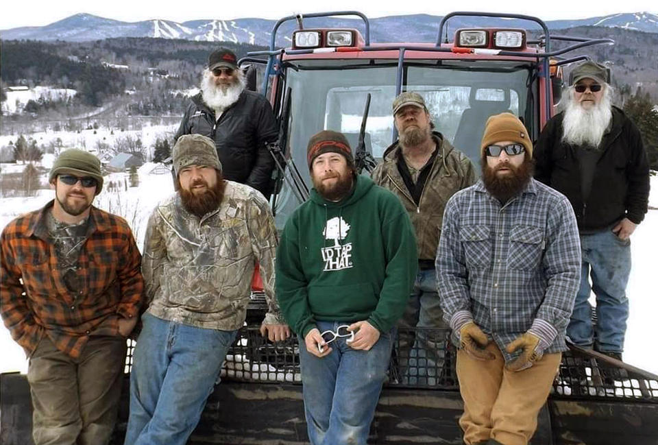 This undated photo provided by Christina MacDonald shows Cleon Boyd, left rear, and his twin brother Leon Boyd, right rear, posing with family members, all who groom ski slopes near Wilmington, Vt. Cleon died from the coronavirus on April 3, 2020. Leon also died from the coronavirus less than a week later. (Christina MacDonald via AP)