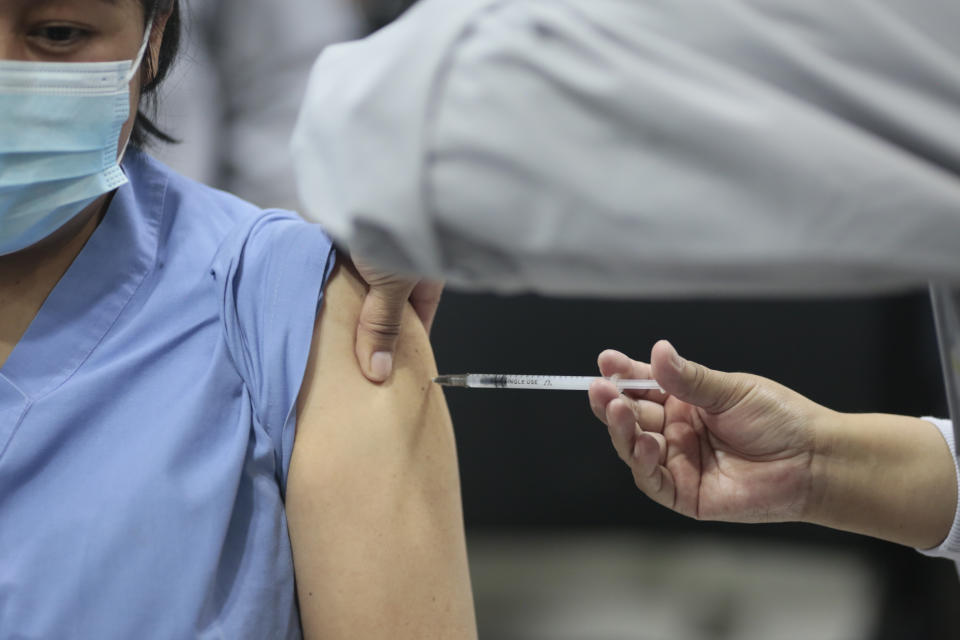 EL ALTO, BOLIVIA - JANUARY 30:  A nurse Inject the vaccine to a nurse as part of the vaccination plan against COVID-19 at Hospital del Norte on January 30, 2021 in El Alto, Bolivia. Bolivia received on January 28th the first batch of 20,000 doses of Russian Sputnik V vaccines that will initially immunize frontline health workers. (Photo by Gaston Brito/Getty Images)