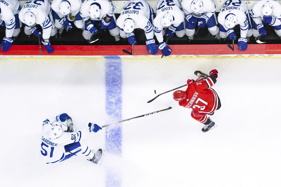 Nov 21, 2018; Raleigh, NC, USA;  Carolina Hurricanes right wing Andrei Svechnikov (37) and Toronto Maple Leafs defenseman Jake Gardiner (51) chase after the puck at PNC Arena. The Carolina Hurricanes defeated the Toronto Maple Leafs 5-2. Mandatory Credit: James Guillory-USA TODAY Sports
