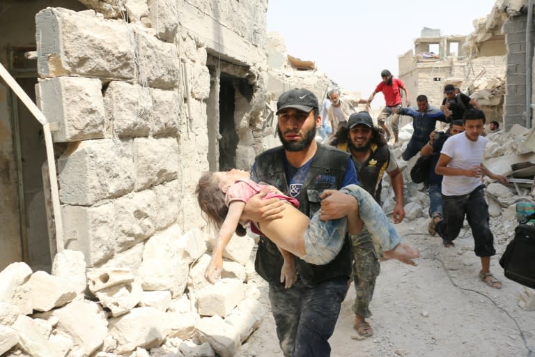 A Syrian man carries a wounded child following a barrel bomb attack on the Bab al-Nayrab neighbourhood of Aleppo on August 25, 2016