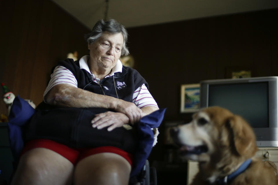 In this Dec. 10, 2013 photo, Sherry Scott sits in a wheel chair, alongside her 10-year-old golden retriever Tootie, at her home in San Diego. Scott, who receives dog food for Tootie through the Animeals program, said she would give her lasagne and pork riblets from Meals on Wheels to Tootie if MOW didn't bring dog food for the dog. The pet food program is sponsored by the Helen Woodward Animal Center. (AP Photo/Gregory Bull)