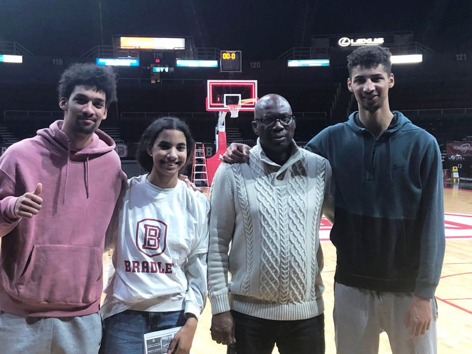 Bradley Braves forward Malevy Leons (on right) with his brother, sister and father during a family visit to Carver Arena this season.