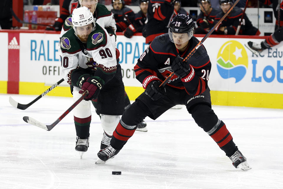 Carolina Hurricanes' Sebastian Aho (20) tries to control the puck in front of Arizona Coyotes' J.J. Moser (90) during the second period of an NHL hockey game in Raleigh, N.C., Wednesday, Nov. 23, 2022. (AP Photo/Karl B DeBlaker)