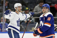 Toronto Maple Leafs left wing Pierre Engvall (47) celebrates scoring a goal as he skates past New York Islanders right wing Josh Bailey in the first period of an NHL hockey game Saturday, Jan. 22, 2022, in Elmont, N.Y. (AP Photo/Adam Hunger)