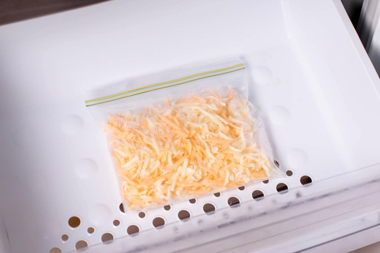 Frozen grated cheese in a bag in the freezer. Frozen food