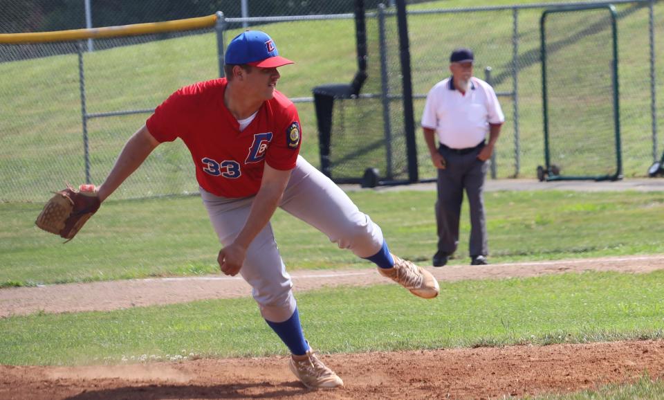 Cambridge Post 84's Hayden Loy (33) follows through after releasing a pitch during Saturday's game with Meigs County in Don Coss Invitational action at Don Coss Stadium. In the background, base umpire Ralph Ray keeps a close eye on the action