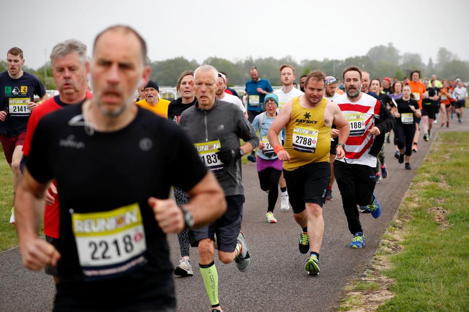 Competitors take part in the non socially-distanced Reunion 5K running race, one of the pilot events in the governments Events Research Programme at Kempton Park southwest London on May 15, 2021. - The event consisting of two separate 5K races, one socially-distanced and the other not, has been designed to provide scientific data on how mass participation events can safely resume as part of the roadmap out of lockdown from 21 June. 
The aim of the Reunion 5K is to provide scientific data from participants, spectators and staff which can be used to inform DCMS in planning for the safe return of mass participation sport and events.
Everyone attending the event was required to provide a negative Covid-19 Lateral Flow Test ahead of the event. Attendees will also be asked to undertake a PCR test both before and after attending the event in order to assist the programmes research. (Photo by ADRIAN DENNIS / AFP) (Photo by ADRIAN DENNIS/AFP via Getty Images)