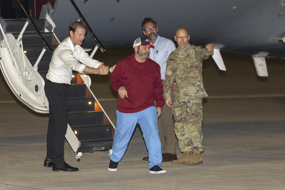 Freed American Jason Saad is welcomed by National Security Council Director for Counter Terrorism David Cotter, left, with Special Presidential Envoy for Hostage Affairs Ambassador Rodger Carstens and Col. Mark Davis as he exits a State Department plane after he and nine fellow detainees were released in a prisoner swap deal between U.S. and Venezuela at Kelly Airfield Annex, Wednesday, Dec. 20, 2023, in San Antonio, Texas. Six of the Americans released arrived at Kelly Airfield Annex. (AP Photo/Stephen Spillman)