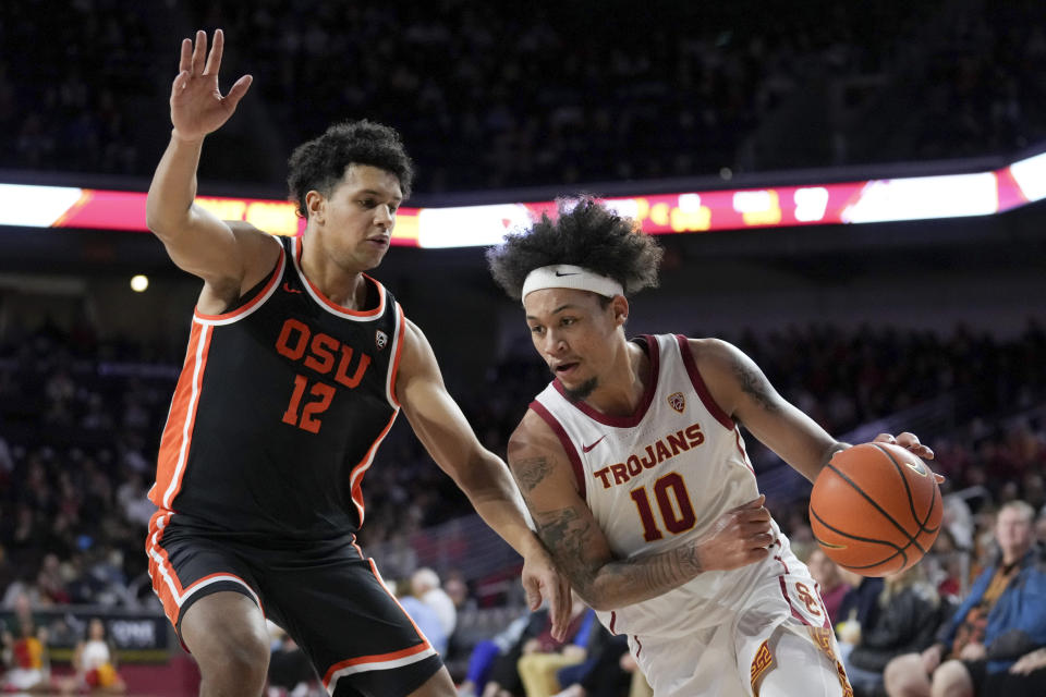 Southern California forward DJ Rodman (10) drives against Oregon State forward Michael Rataj (12) during the first half of an NCAA college basketball game in Los Angeles, Saturday, Feb. 3, 2024. (AP Photo/Eric Thayer)
