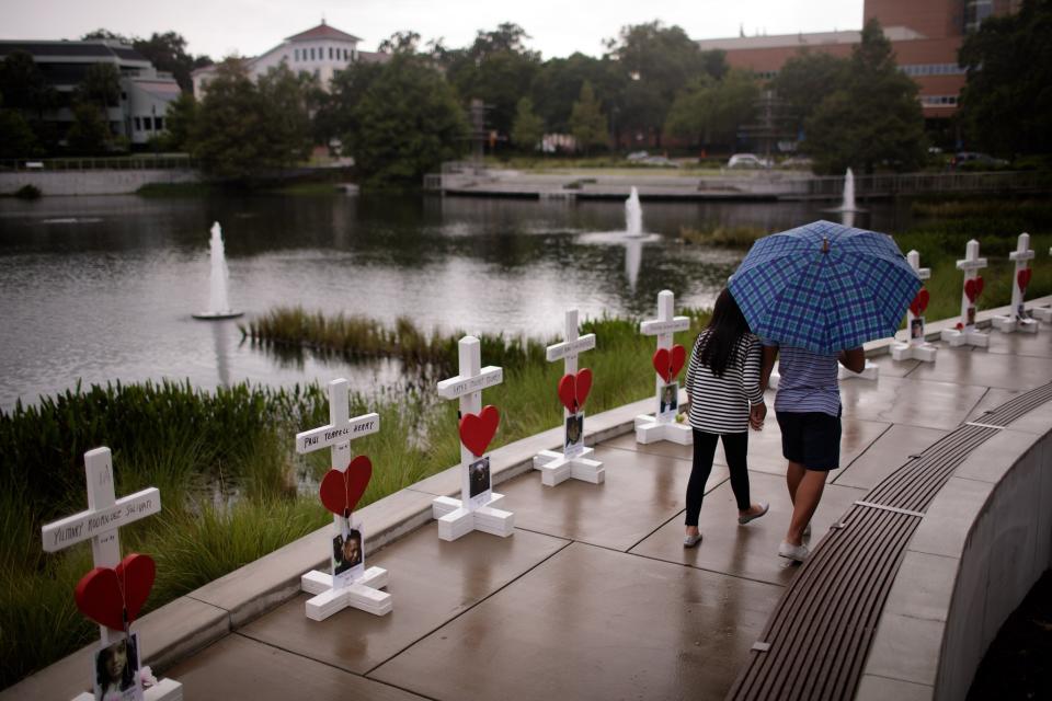 <p>A couple walks past a memorial with wooden crosses for each of the 49 victims of the Pulse Nightclub next to the Orlando Regional Medical Center, June 16, 2016 in Orlando, Florida. (Drew Angerer/Getty Images) </p>