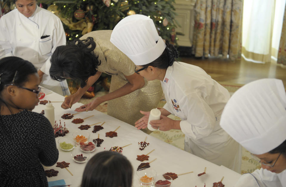 First lady Michelle Obama decorates a lollipop during a holiday decoration preview at the White House in Washington, Wednesday, Nov. 28, 2012. Obama joined children as they decorated holiday treats during a preview of the White House holiday decorations. (AP Photo/Susan Walsh)