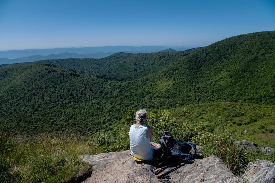 Sharon Smith enjoys the view while eating lunch at the peak of Tennent Mountain July 12, 2023.