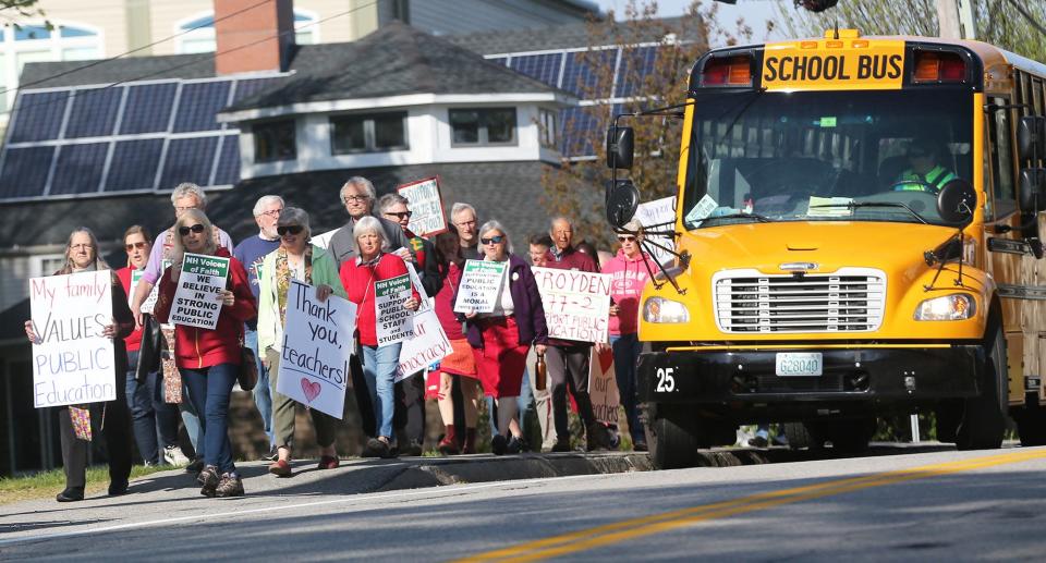 People hold signs in support of public schools and protesting New Hampshire Education Commissioner Frank Edelblut in Durham Thursday, May 12, 2022, before a state Board of Education meeting at Oyster River Middle School.