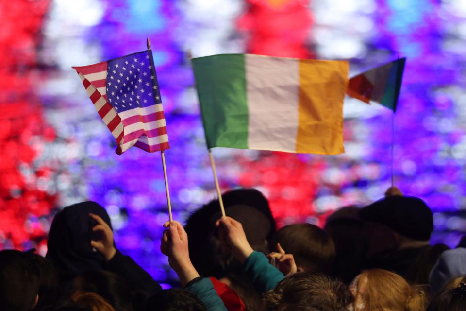 People wave Irish and US flags as they listen to President Joe Biden give a speech outside St Muredach's Cathedral, in Ballina, Ireland, Friday, April 14, 2023. (AP Photo/Peter Morrison