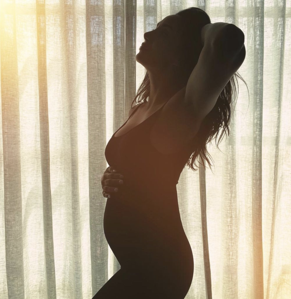 Snezana Wood feeling her pregnant belly