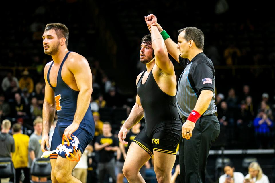 Iowa's Tony Cassioppi, center, has his hand raised after winning via stalling disqualification against Illinois' Matt Wroblewski at 285 pounds during a NCAA Big Ten Conference men's wrestling dual, Friday, Jan. 6, 2023, at Carver-Hawkeye Arena in Iowa City, Iowa.