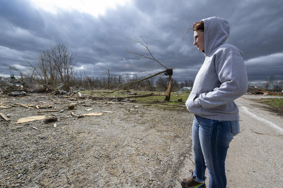 Jaycee Ahlefeld surveys the damage left after a late-night tornado devastated the area in Sullivan, Ind., Saturday, April 1, 2023. Ahlefeld's son attended a day care that had been on what is now an empty lot. Multiple deaths were reported in the area following the storm. (AP Photo/Doug McSchooler)