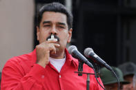 Venezuela's President Nicolas Maduro kisses a crucifix as he speaks during a pro-government rally at Miraflores Palace in Caracas, Venezuela October 25, 2016. REUTERS/Carlos Garcia Rawlins