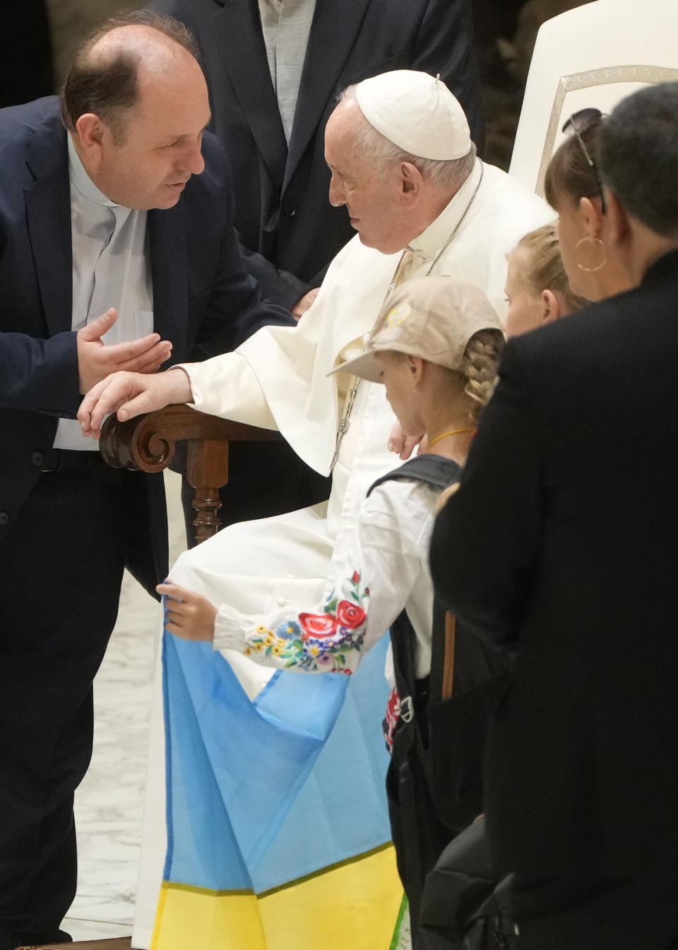 Children bring an Ukrainian national flag to Pope Francis during his weekly general audience in the Paul VI Hall at The Vatican, Wednesday, Aug. 24, 2022. Pope Francis marked the sixth month start of Russia's invasion of Ukraine on Wednesday by denouncing the "insanity" of war, warning against the risk of nuclear "disaster" and lamenting that innocents on both sides were paying the price. (AP Photo/Gregorio Borgia)