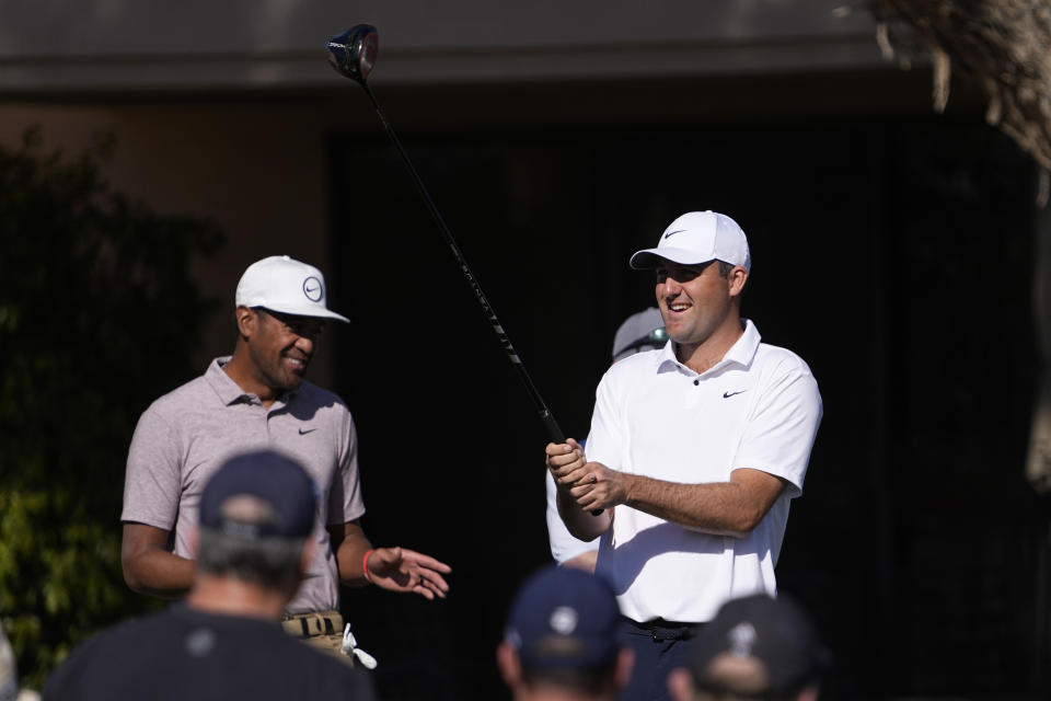Scottie Scheffler, right, smiles next to Tony Finau as he prepares to hit from the fifth tee during the American Express golf tournament on the Pete Dye Stadium Course at PGA West Saturday, Jan. 21, 2023, in La Quinta, Calif. (AP Photo/Mark J. Terrill)
