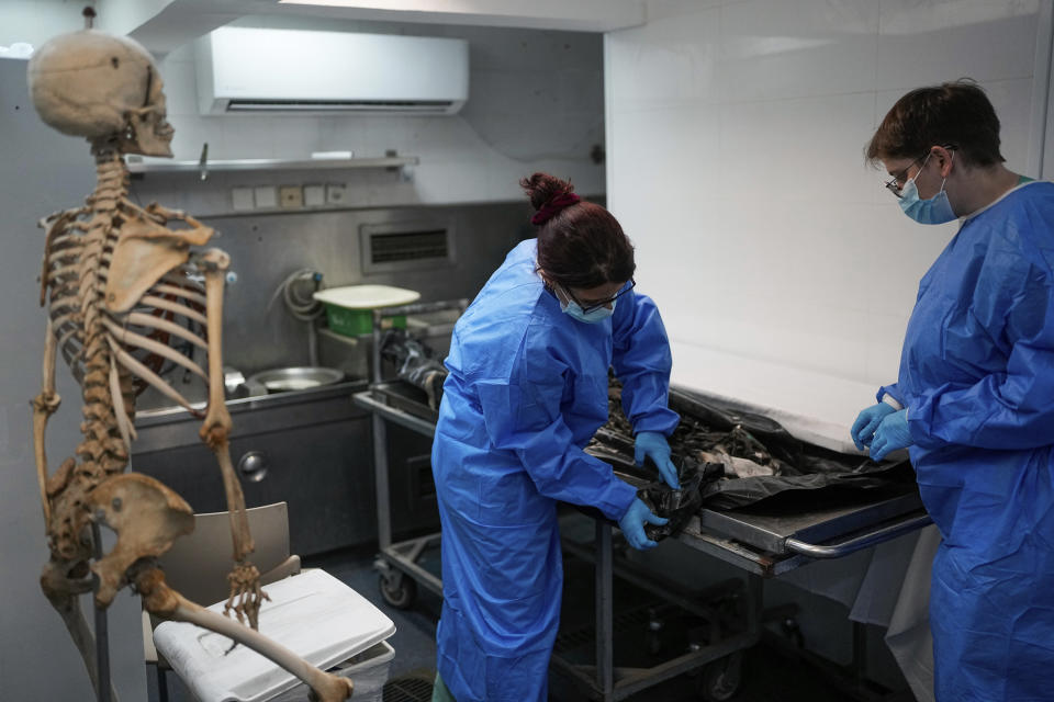 Israeli forensic experts work on bodies of Israelis killed by Hamas militants in the National Center for Forensic Medicine in Tel Aviv, Israel, Wednesday, Oct. 18, 2023. On Oct. 7, the militant Hamas rulers of the Gaza Strip carried out an unprecedented, multi-front attack on Israel. More than 1,400 people were killed and some 200 captured. (AP Photo/Ohad Zwigenberg)