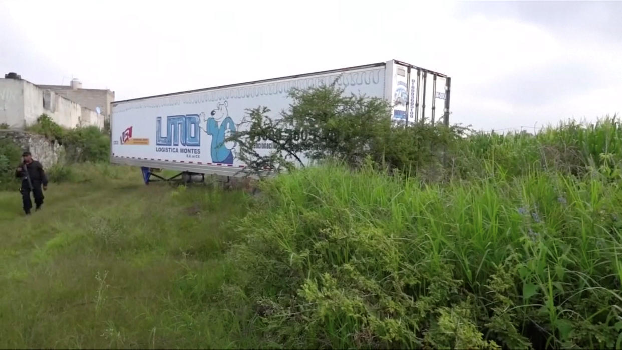 A police officer walks past an abandoned trailer full of bodies in Tlajomulco de Zuniga, Jalisco, Mexico (Picture: Reuters)