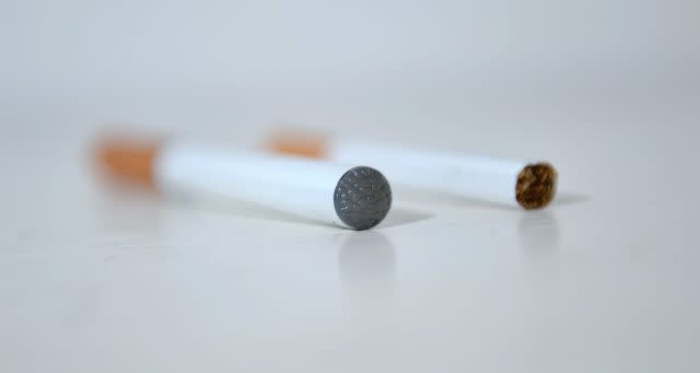 An e-cigarette next to a normal cigarette