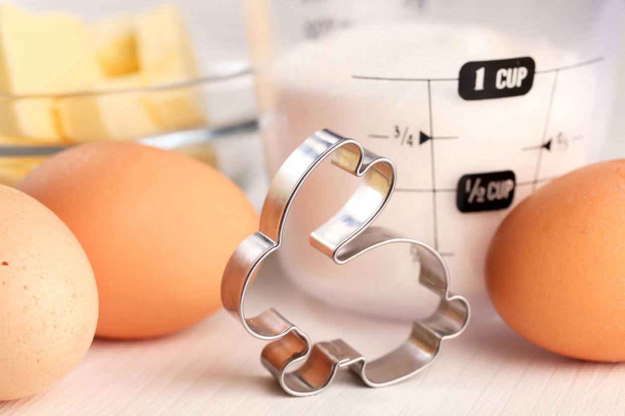 Bunny cookie cutter with eggs and baking ingredients in the background