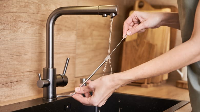 woman scrubs a reusable straw