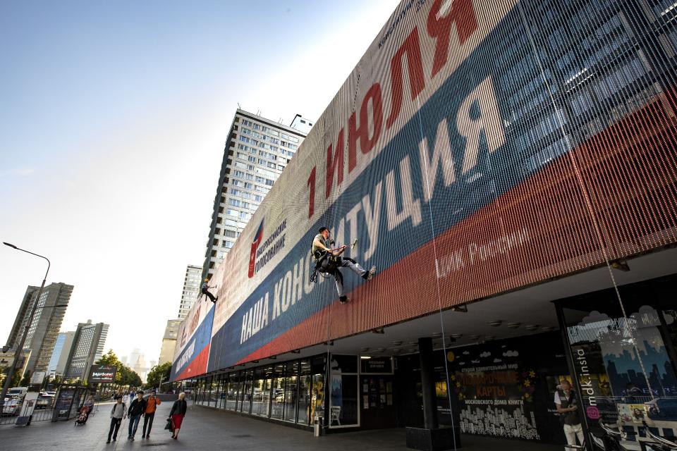 FILE - In this June 22, 2020, file photo, a worker cleans an electronic scoreboard reading "All-Russia voting, July 1, Our Constitution" in the center of Moscow, Russia. Russian President Vladimir Putin is just a step away from bringing about the constitutional changes that would allow him to extend his rule until 2036. The vote that would reset the clock on Putin’s tenure in office and allow him to serve two more six-year terms is set to wrap up Wednesday, July 1, 2020. (AP Photo/Alexander Zemlianichenko, File)