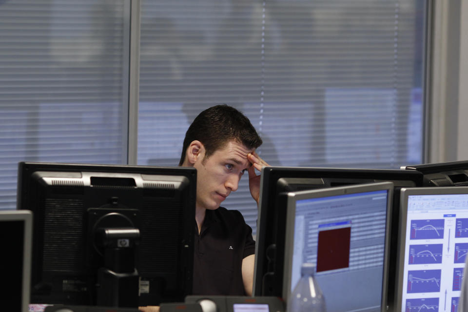 A trader monitors his screen on a trading floor in London. The FTSE was down on the day