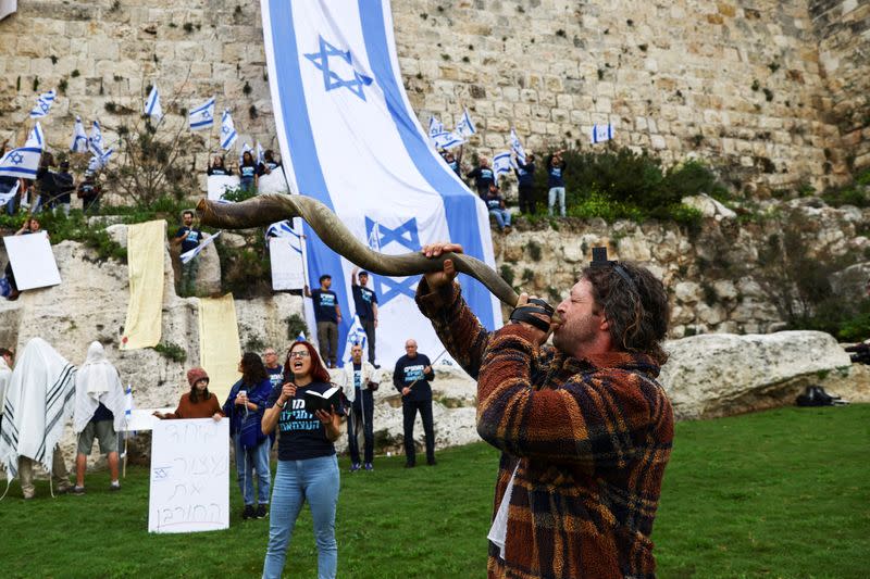 Demonstrators hang flags on the walls of Jerusalem's Old City in an act of protest as Israelis launch "Day of Shutdown” against judicial overhaul