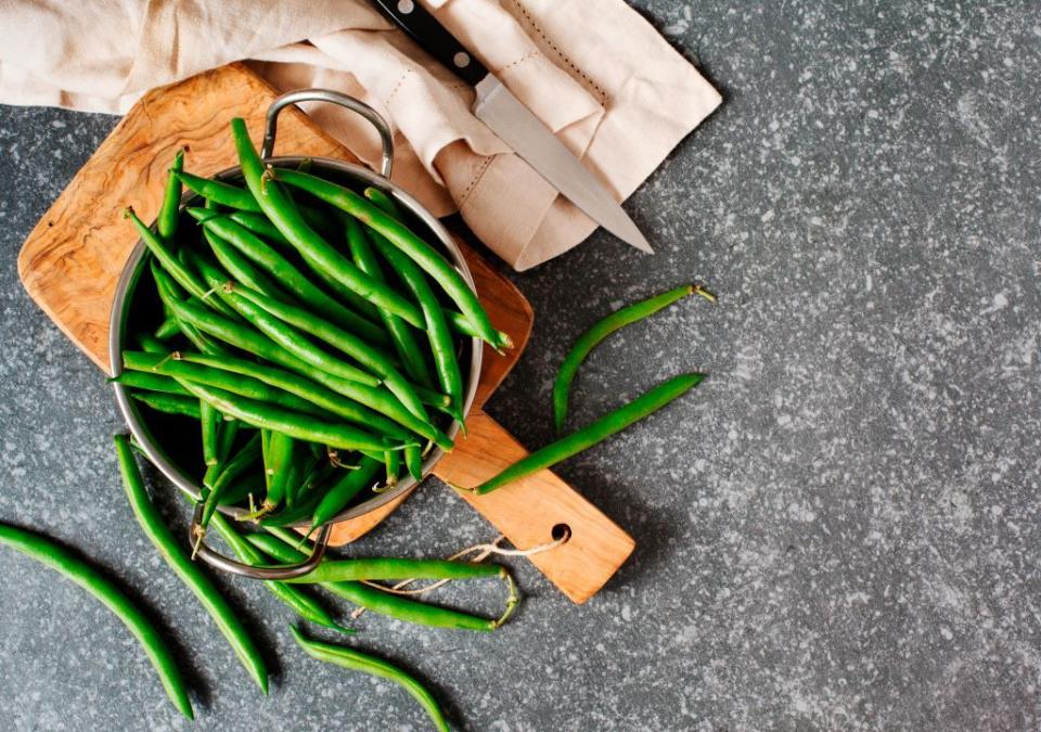 green beans in bowl on gray stone background top view copy space