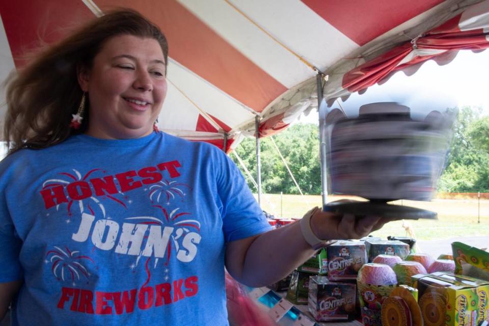 Amy Ritter, owner of Honest John's Fireworks in Riverside, Missouri, displays a rotating fireworks fountain.