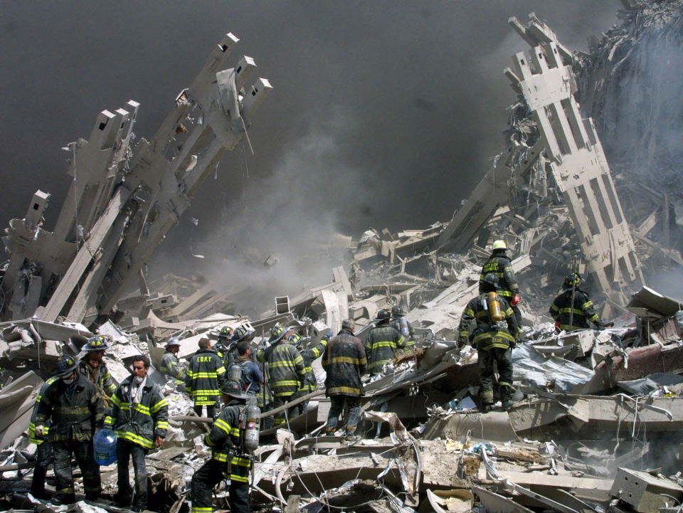 FILE - Firefighters make their way through the rubble after two airliners crashed into the World Trade Center in New York bringing down the landmark buildings, Sept. 11, 2001. President Joe Biden signed an executive order, Friday, Feb. 11, 2022, to create a pathway to split $7 billion in Afghan assets frozen in the U.S. to fund humanitarian relief in Afghanistan and to create a trust fund to compensate Sept. 11 victims. (AP Photo/Shawn Baldwin, File)
