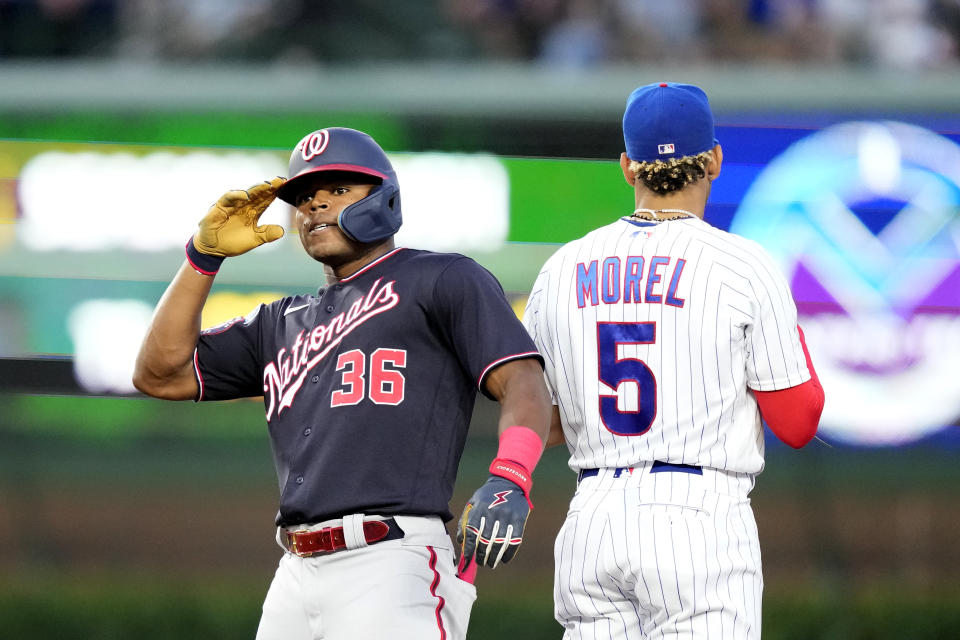 Washington Nationals' Stone Garrett salutes his teammates after his double off Chicago Cubs starting pitcher Drew Smyly, as second baseman Christopher Morel stands behind during the fourth inning of a baseball game Monday, July 17, 2023, in Chicago. (AP Photo/Charles Rex Arbogast)