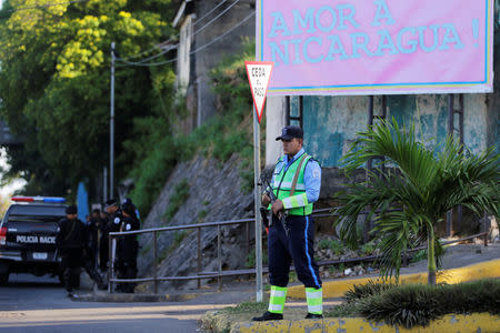 A police officer stands guard in front of 100% Noticias Channel building after its director Miguel Mora was arrested by national police in Managua, Nicaragua December 22, 2018. REUTERS/Oswaldo Rivas