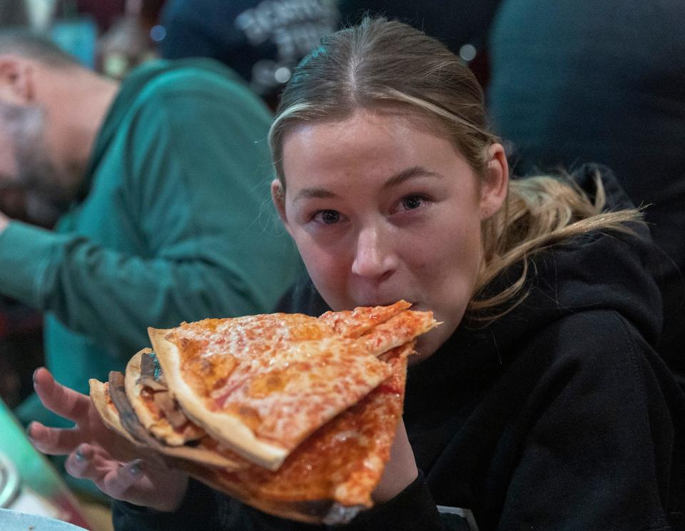 Emma Larkin, 18, of Ocean Township, tries the triple-slice approach to complete the Carmen's Pizza challenge at Pete and Elda's Bar. Her reward: a coveted Whole Pie-Eater's Club T-shirt.