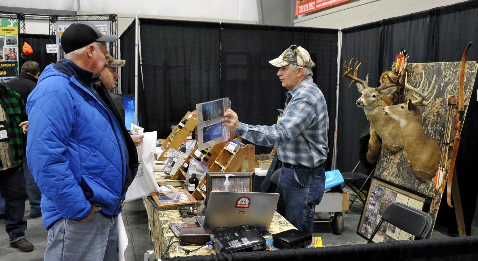 Jim Riggle of Smoky's Deer Lure shows attendees of the Northeast Ohio Sportsman Show how his animal lures work. The show, in Mount Hope, continues today and Saturday.